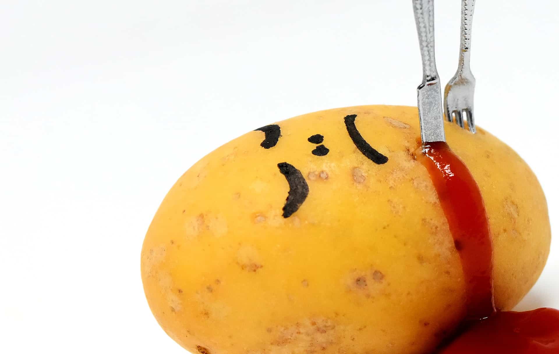 Potato prick with mini fork and knife and a ketchup