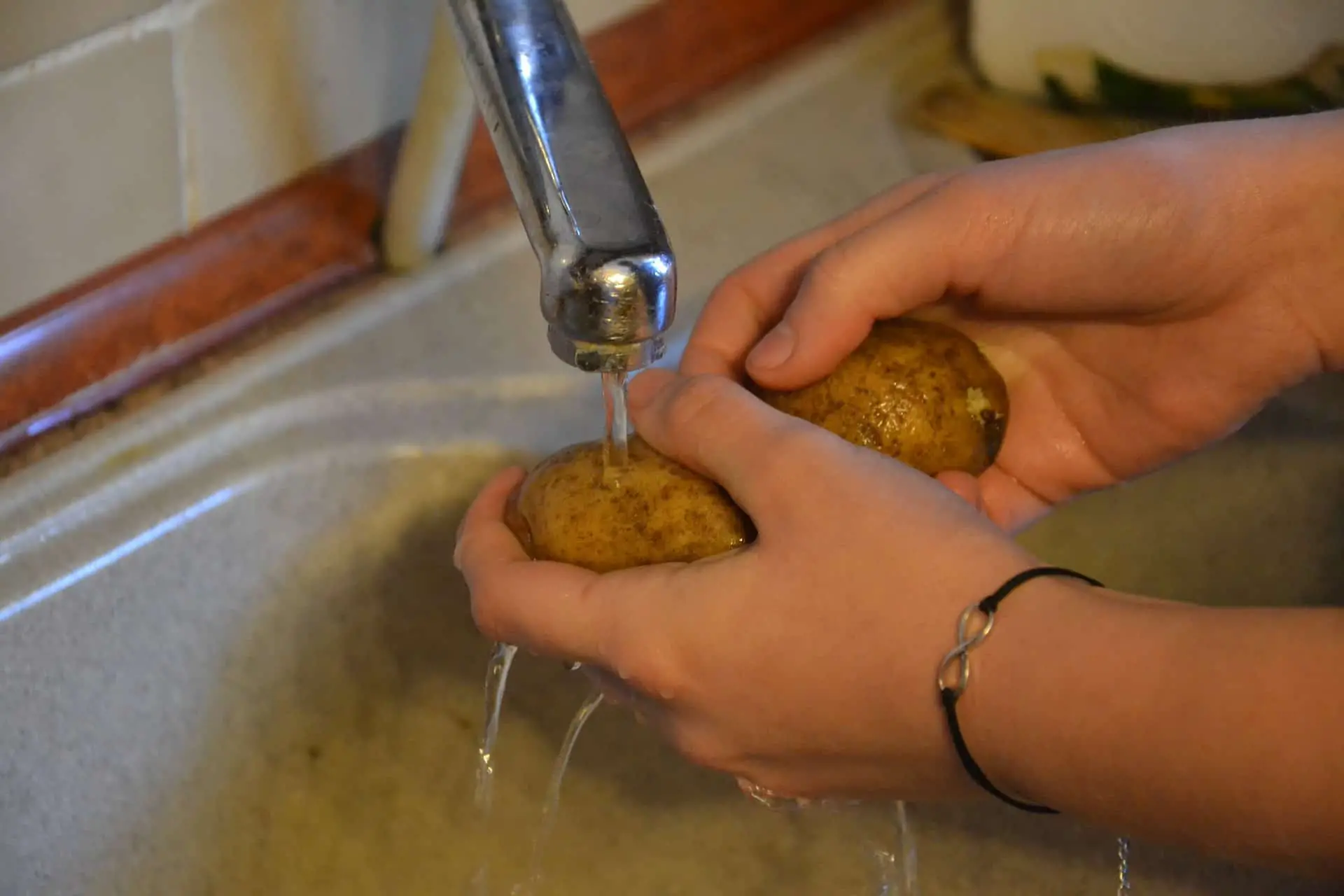 2 hands Rinsing Potatoes
